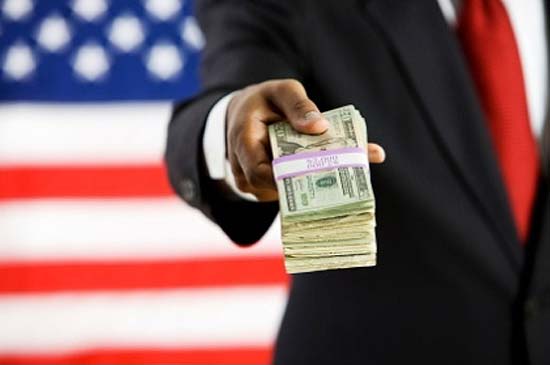 Photo of man handing money to you with an American flag behind 