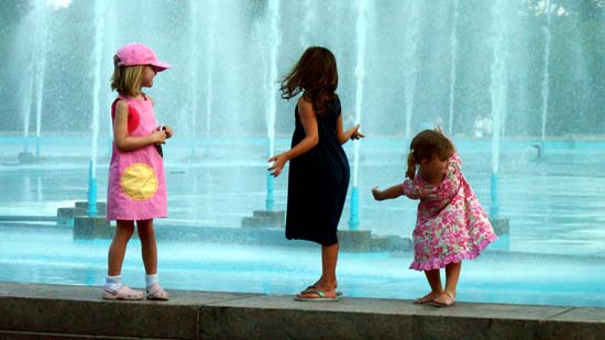 Photo of Three Girls Playing by a Fountain
