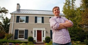 Photo of Dan Hofmann in front of a Louisville home with solar panels on the roof