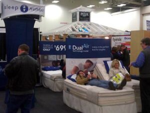 Photo of some people trying out the Sleep Number bed by Select Comfort