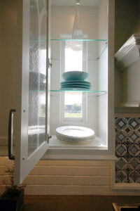 Photo of a small window designed to fit nicely behind a clear glassed kitchen cabinet Rock Springs Homearama