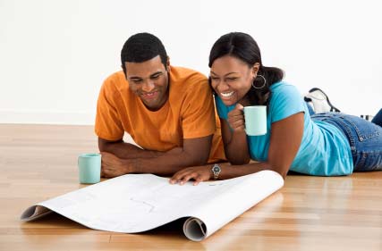 Photo of two home buyers looking at building plans.