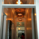 Photo of hallway with tall ceilings and a brick treatment by Tre Pryor