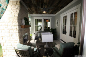 Photo of a covered porch with fireplace and concrete floors by Tre Pryor