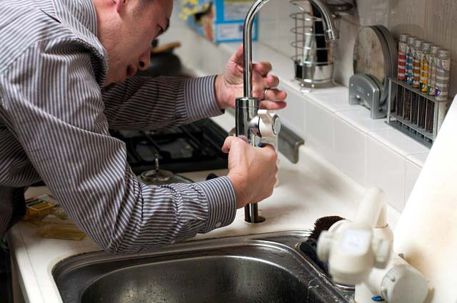 Photo of plumber installing faucet