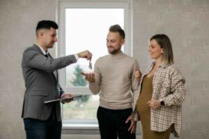 Photo of a real estate agent giving keys to the new owners of a home